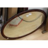 An Edwardian style inlaid mahogany oval wall mirror