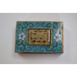 A Cloissonne match box holder, inset with a central carved jade stone,