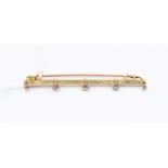 An Edwardian diamond five-stone 15ct yellow gold bar brooch, five round old-cut diamonds approx 0.