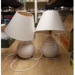 Two art pottery lamps basses in pale pink and cream together with two cream shades