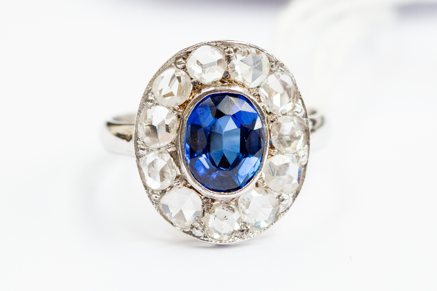 A diamond and sapphire cluster ring, central set oval sapphire approx 5mm x 8mm,