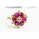 A ruby and diamond cluster ring claw set, diamond centre with ruby surround, 18ct gold, size N,