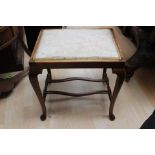 A mahogany stool with cream upholstery