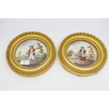 A pair of 19th Century circular porcelain plaques, each painted with country,