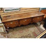 George III oak three drawer dresser base with brass wing handles on padded feet