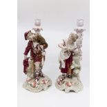 A pair of German porcelain candle sticks of a lady and gentleman, marked PT to base,