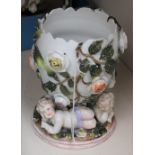 A German porcelain egg vase with cherubs, applied roses and rose leaves, in the manner of Meissen,