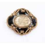 A Victorian yellow metal mourning brooch, enamel and hair window, inscribed to reverse, dated 1869,