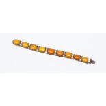 An butterscotch amber and silver bracelet, comprising oval amber links,