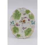 An 18th century oval dish, molded in relief with fruiting vines, painted with flowers,