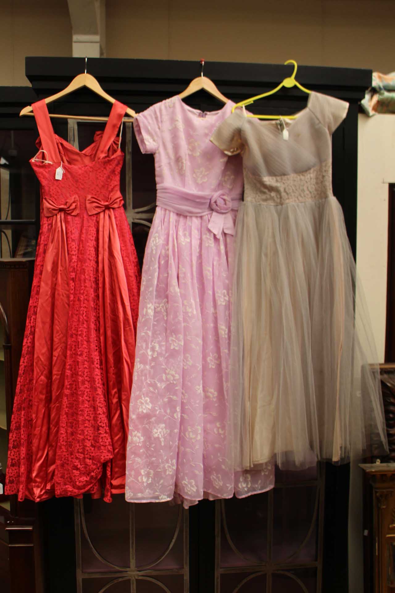 A stunning collection of three dresses to include; a pale grey evening dress,