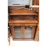 An early Victorian rosewood chiffonier, the upper section with a raised shelf to back,