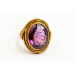 A large amethyst dress ring, oval stone approx 12mm x 16mm, rope edge, unmarked 18ct gold, size O½,