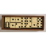 A boxed set complete of Edwardian ebony and ivory dominoes