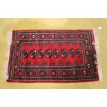 A red ground woollen rug, hand knotted,