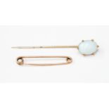 An Edwardian gilt metal synthetic Opal type glass set stick pin and an unmarked rose metal tie pin,