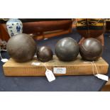 Group of four cannon balls (various sizes) on plinth