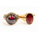 A garnet cabochon 9ct gold ring, size M, along with a faceted oval garnet and 9ct gold ring, size O,