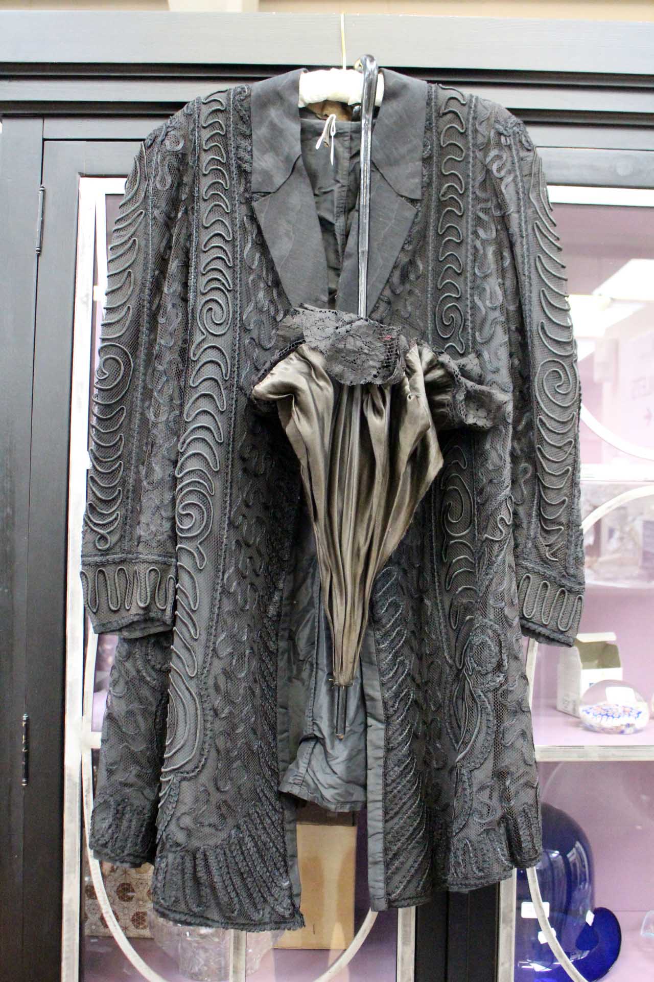 A late Victorian or early Edwardian mourning coat, embellished in lace, fully lined,