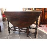 An early 20th Century oak drop down two leaf ball turned dining table