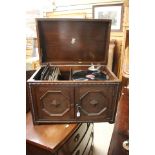 A Mid 20th Century oak Apollo marked HMV Record Player, with a collection of records.