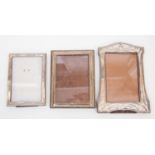 Three silver photo frames,