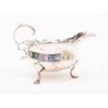 A George III silver sauce boat, ogee border and C scroll handle, on three trefoil feet,