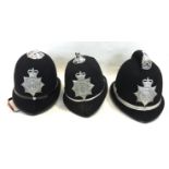 A collection of three Welsh Policemans helmets: One North Wales Constabulary and two South Wales