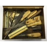 A tin containing spare tools for the private purchase Kukri knife to include corkscrew, five knives,