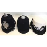 A Devon & Cornwall Police Helmet with Queens Crown badge, a Greater Manchester Police WPC's cap,