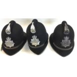 A collection of three Greater Manchester Police Helmets. All with Queens Crown badges.