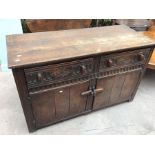 An early 20th Century bespoke oak dresser base, with plank doors and back, comprising two drawers