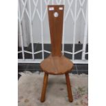 A 20th Century solid elm three legged chair
