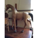 A 20th Century large wooden male horse sculpture, in standing position, covered in a tan leather