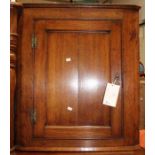 A 19th Century oak hanging corner cupboard, the single door opening to reveal a two shelves
