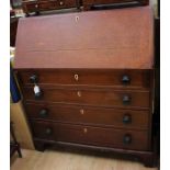 An early 19th Century oak bureau, the fall opening to reveal a fitted interior over four long