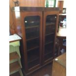 A Victorian mahogany two door glazed bookcase, enclosing four adjustable shelves, originally the