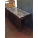 A George III oak drop leaf dining table, raised on square legs