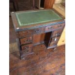 An Early 20th Century Mahogany Writing Desk with green & gold leather inlay, eight drawers and