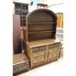 A Jacobean style oak suite of furniture, comprising dresser, TV stand, corner cabinet, and a court