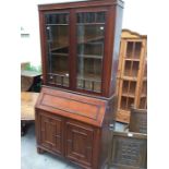 A late Victorian walnut bureau bookcase, circa 1890, the upper section with glazed doors enclosing