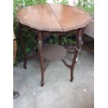 An Edwardian mahogany two-tier occasional table, the top with a shaped edge, raised on six legs,