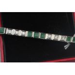 A 14ct. white gold, emerald and diamond bracelet, formed from sets of links flush set round