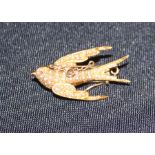 A 15ct. gold and seed pearl "swallow" brooch, fashioned as a swallow in flight, set numerous