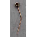 A yellow metal tie pin, set seed pearls and red stone to centre, (as found, yellow metal assessed as