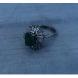 A 14ct. white gold, emerald and diamond ring, the mount four claw set emerald cut emerald to