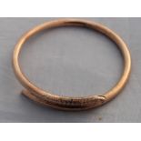 A 9ct. rose gold "serpent" slave bangle, fashioned as a coiled snake with open mouth with engraved