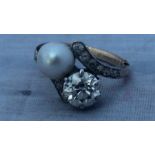 A diamond and pearl cross-over ring, set round brilliant cut diamond (diamond weight approx. 1.65
