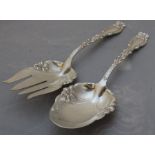 A pair of American sterling silver servers, the bowls embossed in the Art Nouveau taste, relief cast