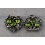 A pair of Edwardian precious white metal and peridot dress clips, each fashioned as as heart